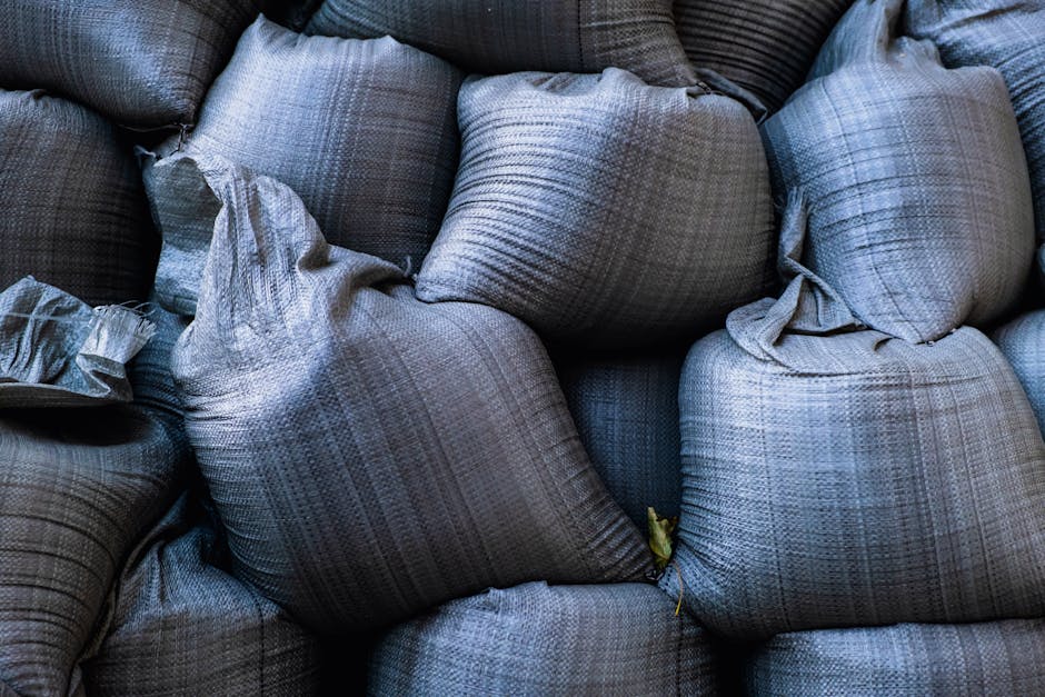 Close-up of hands building a sandbag wall together