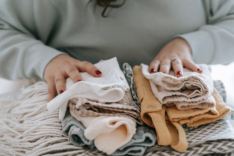 Close-up of hands organizing folded clothes in drawers