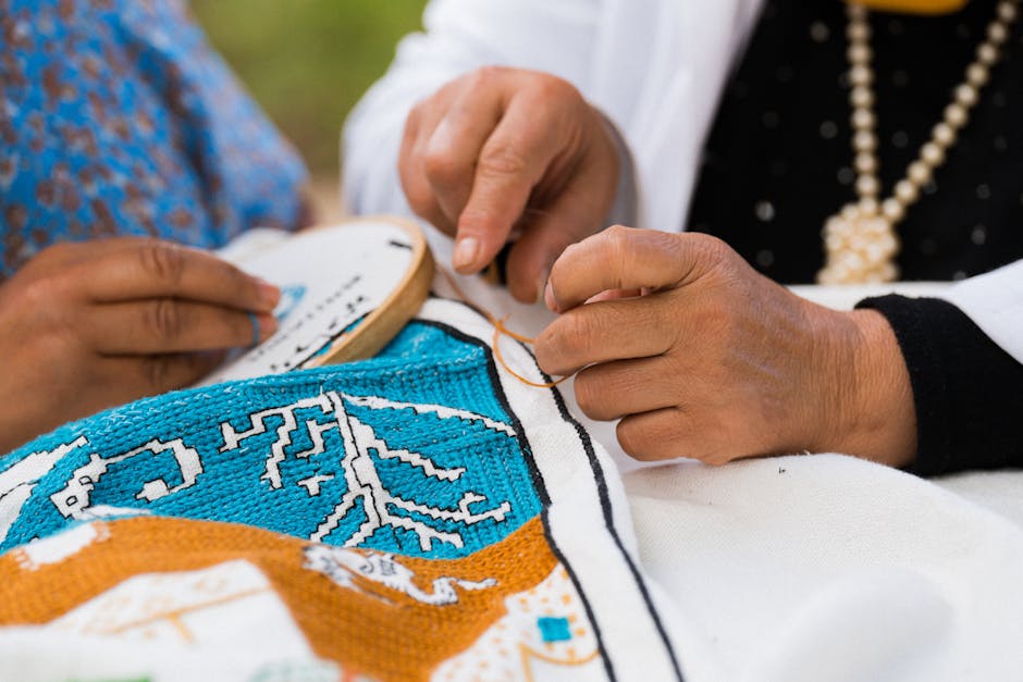 Close up of hands sewing national ornament on fabric