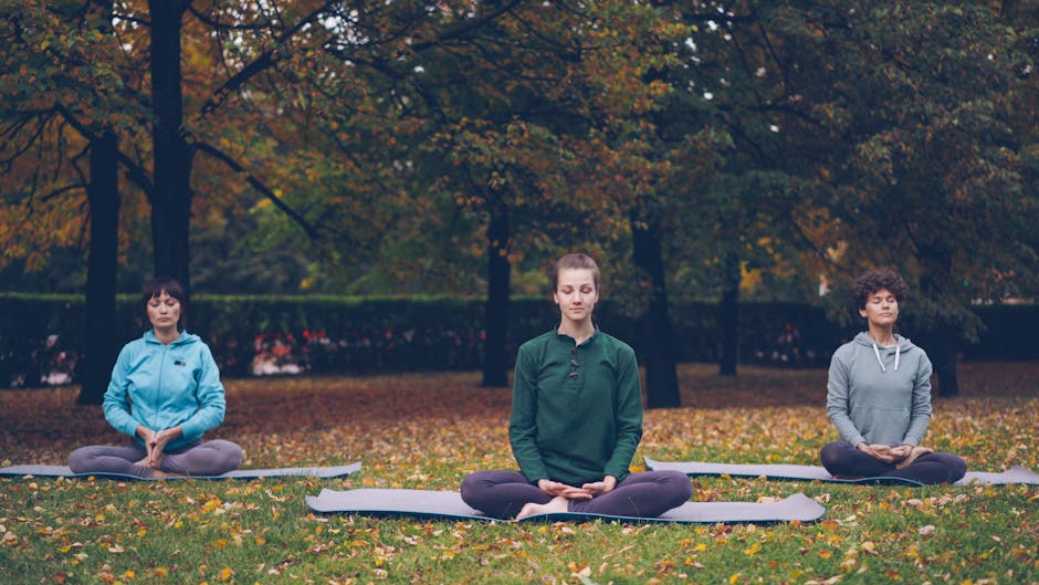 diverse group young adults meditating park