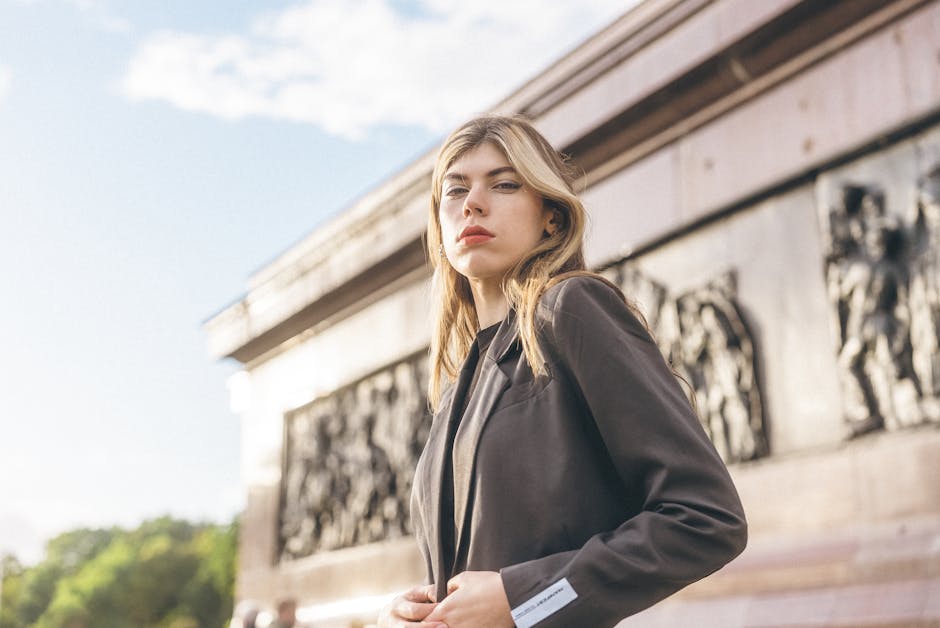 elegant woman adjusting blazer in city street