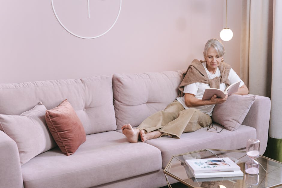 Fashionable woman reading book on comfortable sofa