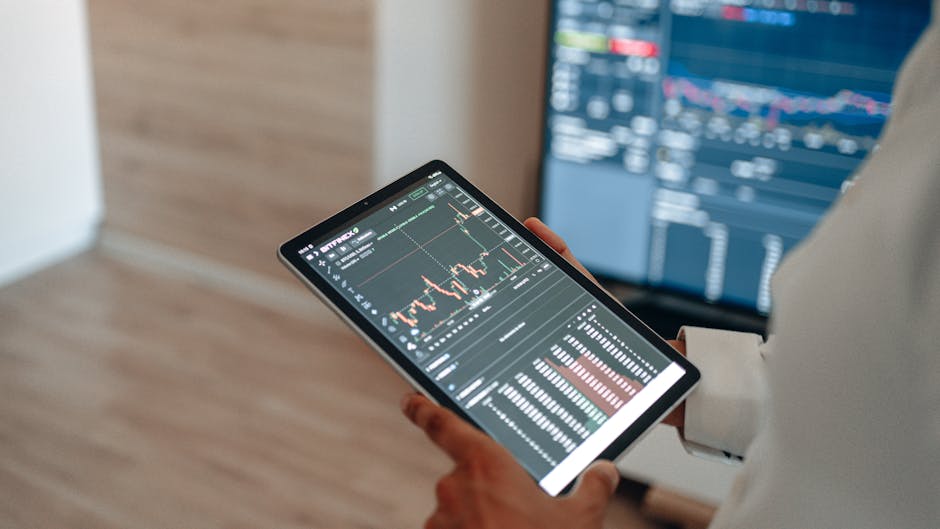 Financial data analytics dashboard on large screen, with blurred office workers in the background, showcasing AI-driven insights.