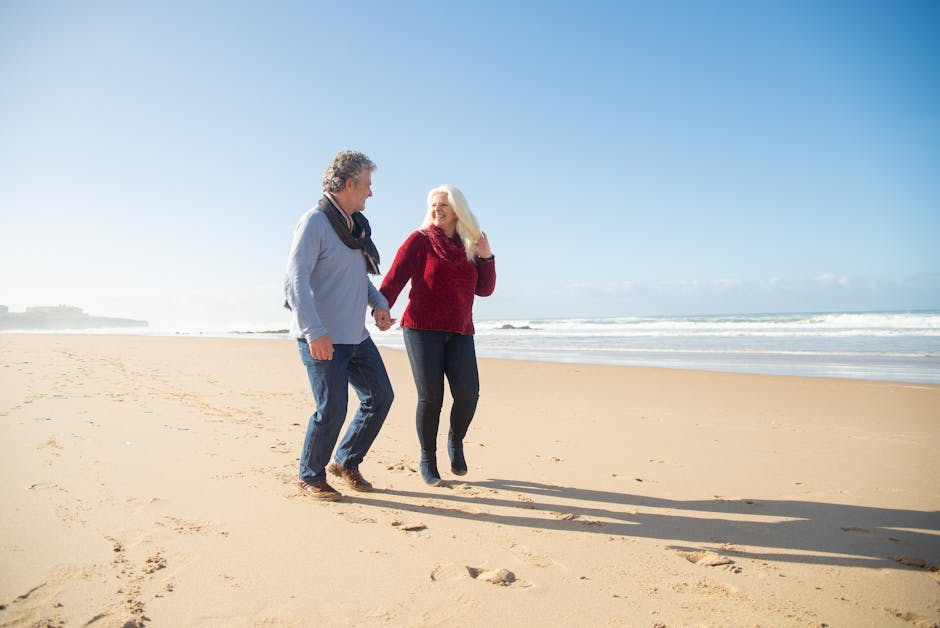 happy elderly couple walking beach sunset
