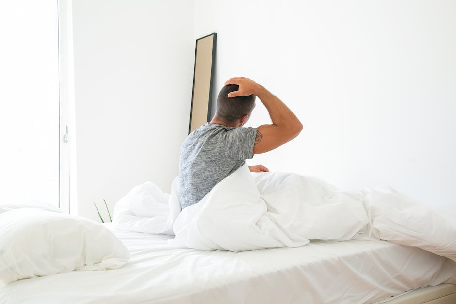 person stretching in bed morning sun