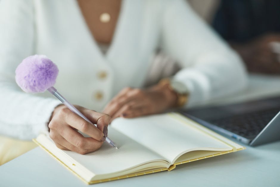 person writing in journal at desk