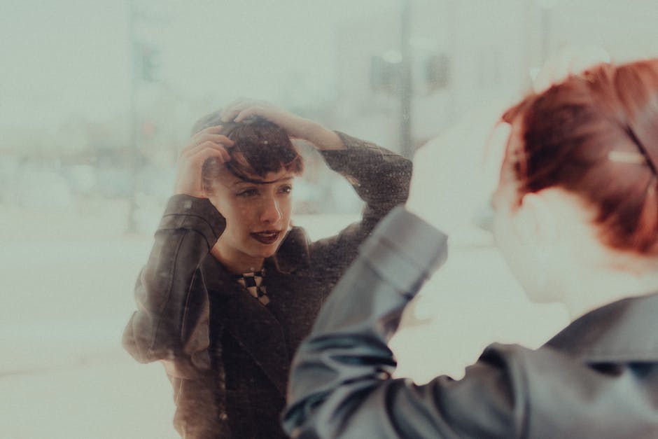 woman adjusting jacket mirror