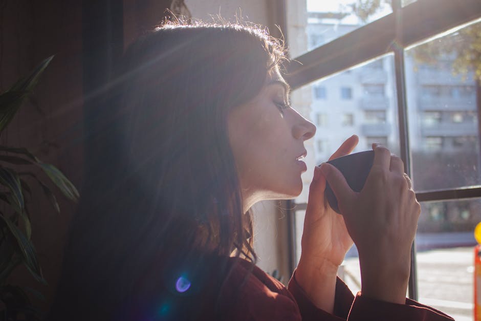 Woman drinking tea by window