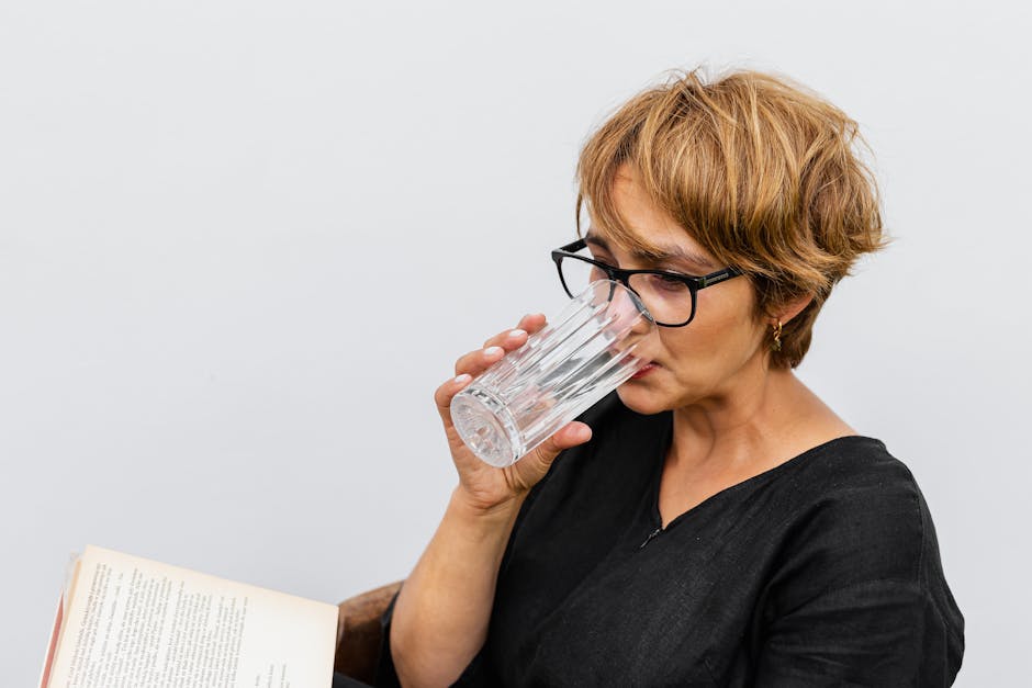 woman drinking water and reading book