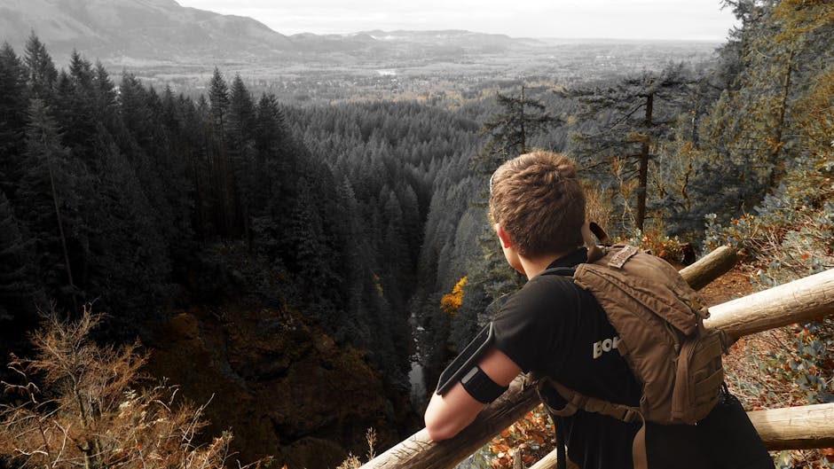 Woman hiking on a trail overlooking a vast waterfall
