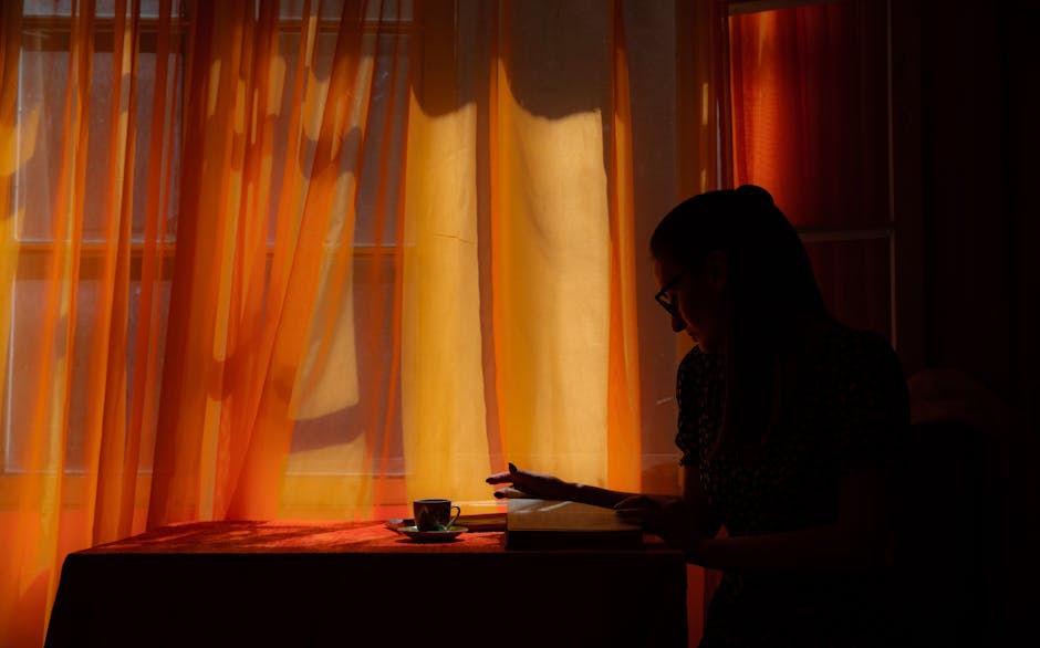 woman meditating by window with sunrise
