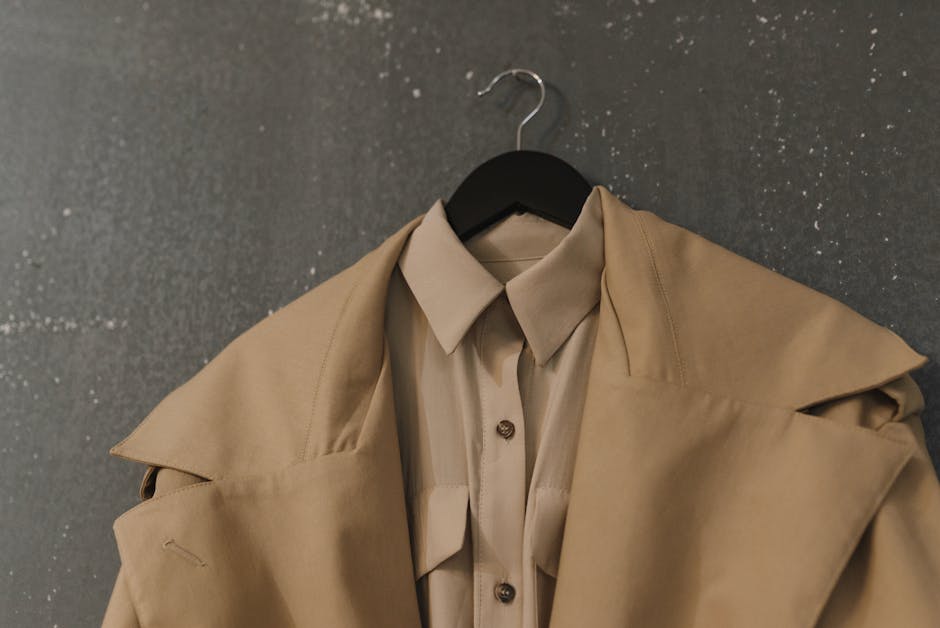 woman trying on classic trench coat in stylish minimalist closet